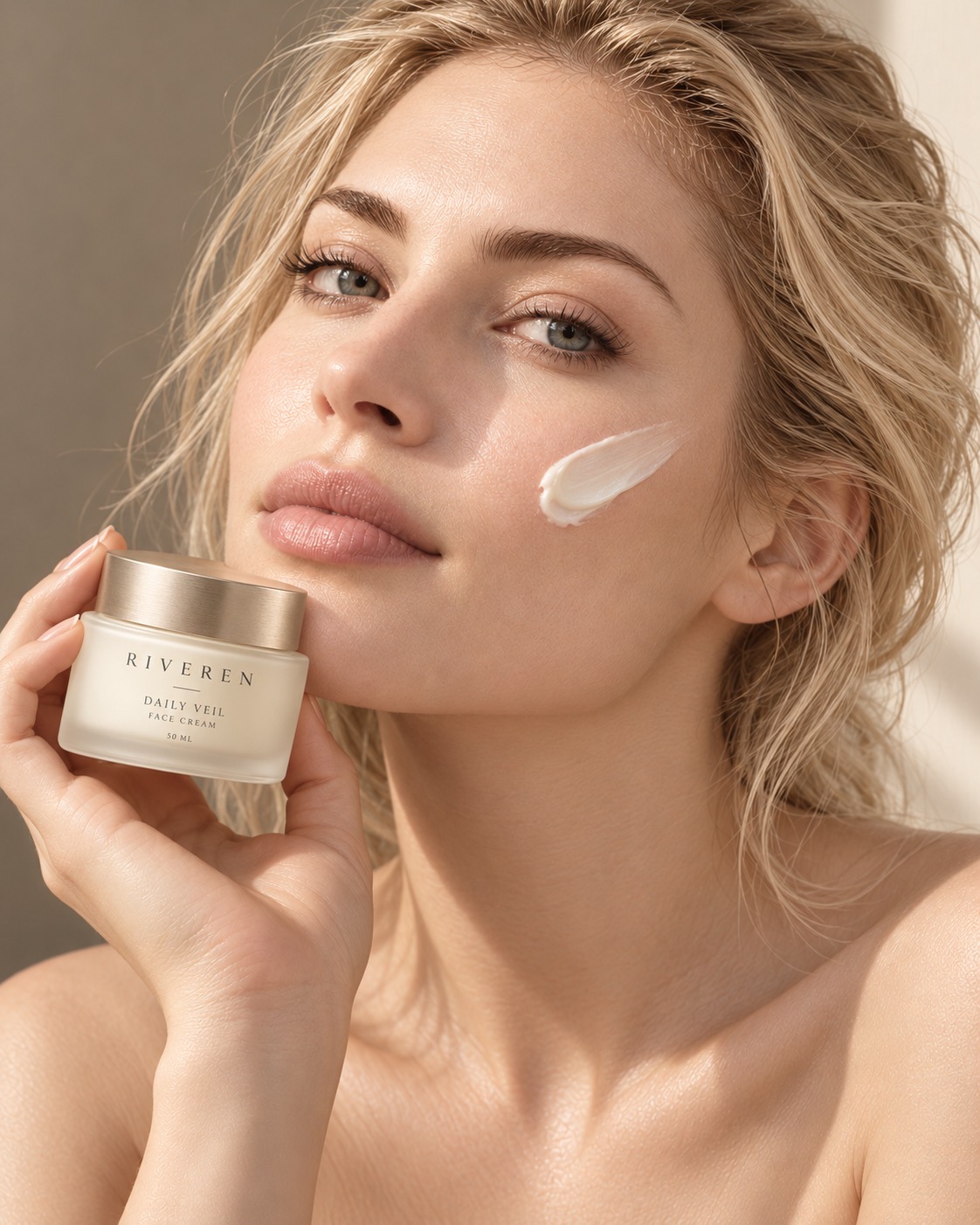 A blonde woman holding Riveren Daily Veil, with a swipe of cream on her cheek